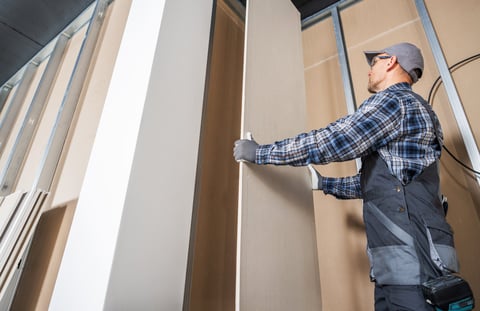 Worker installing drywall
