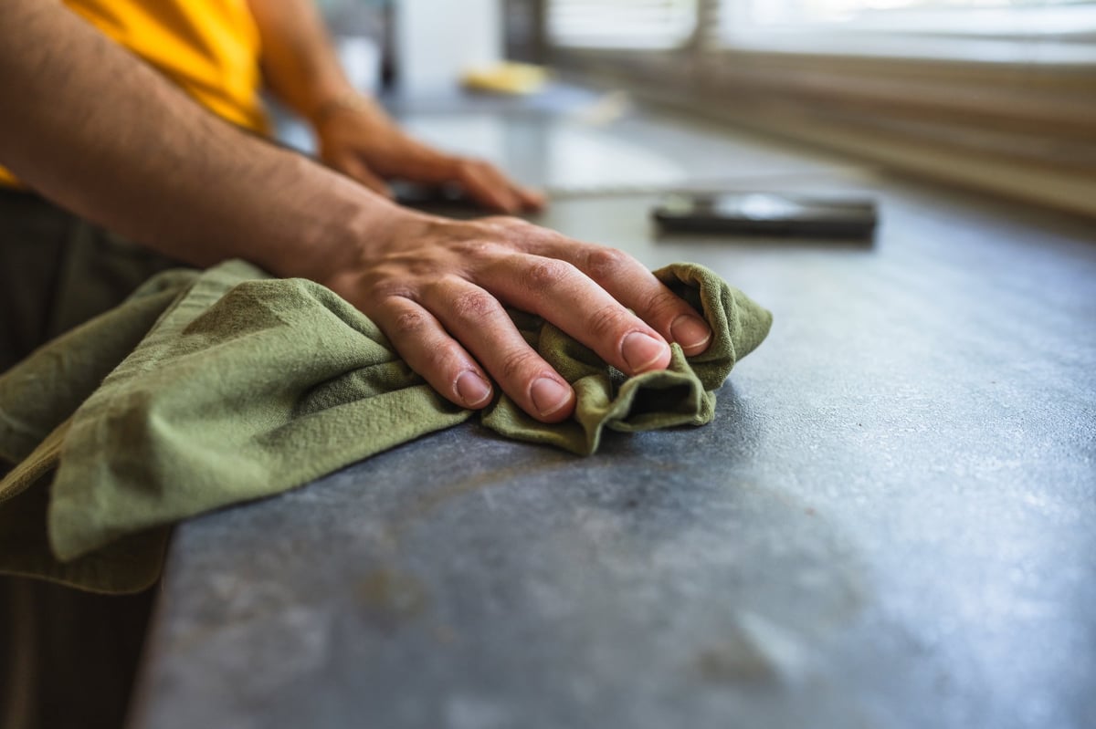 Professional cleaning hands wiping and disinfecting a kitchen counter